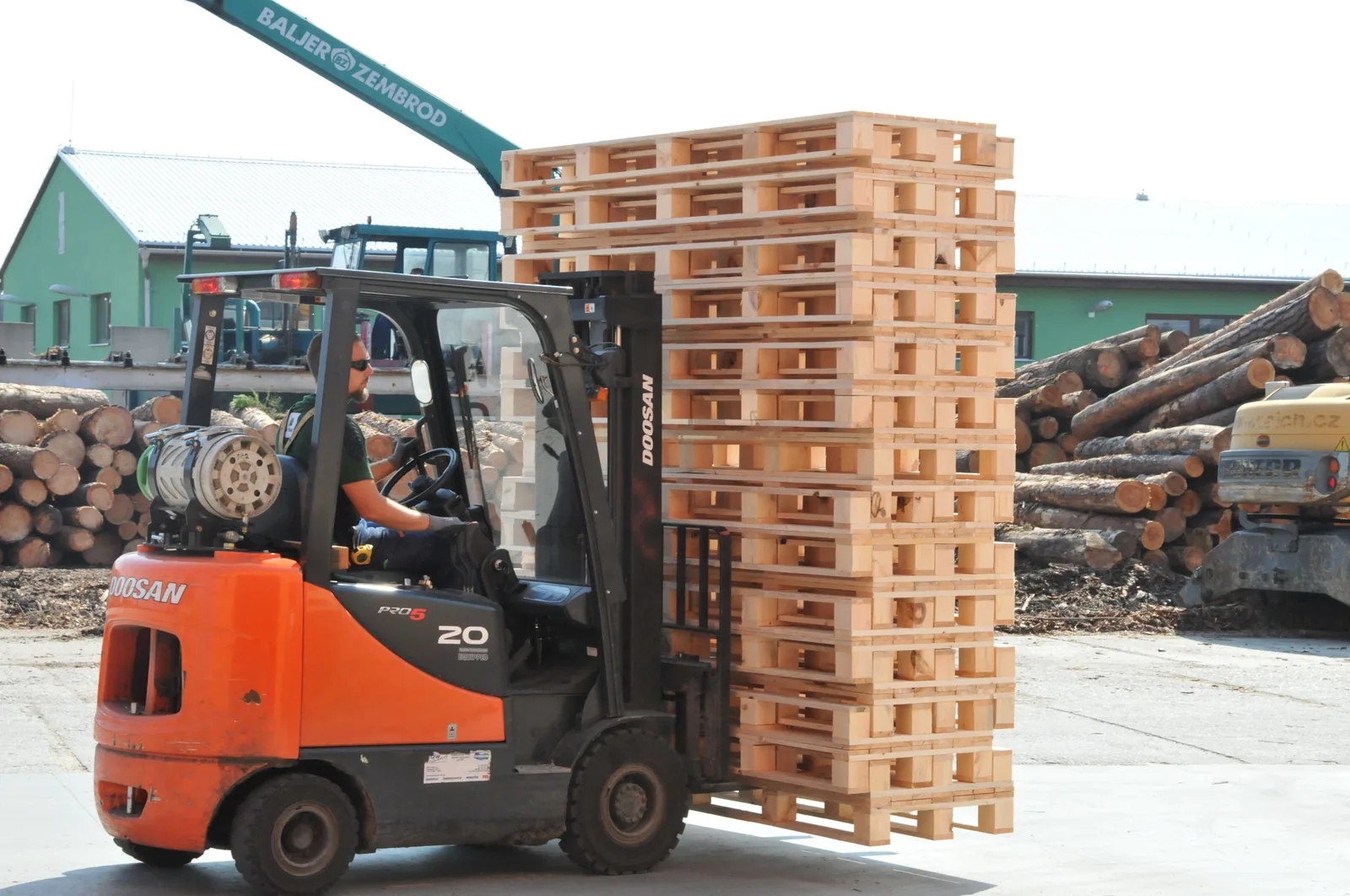 Forklift moving finished wooden pallets at the sawmill