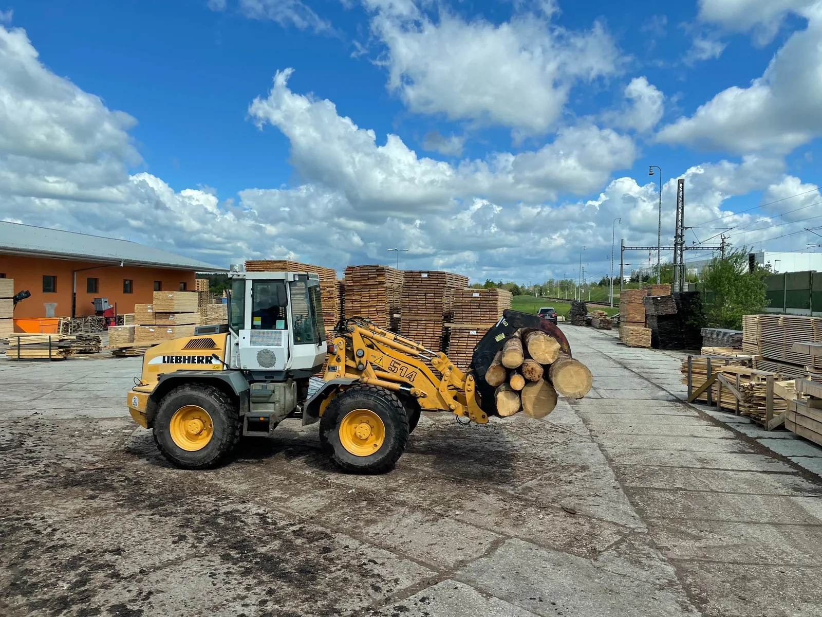 Wheel loader transporting logs through the sawmill yard